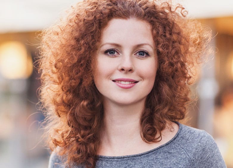 young red haired woman with smooth skin smiling