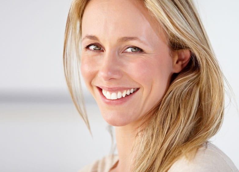 Blonde woman smiling over her shoulder 