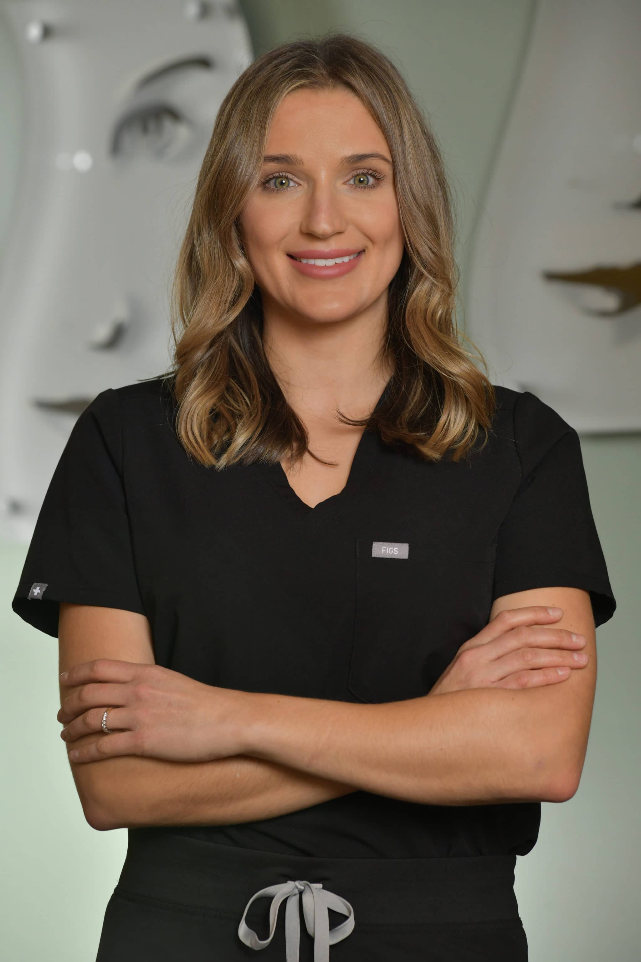 Headshot of female doctor smiling and folding arms in a relaxed manner