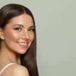 Pretty model woman with clear skin and long healthy straight hair. Skincare and facial treatment concept