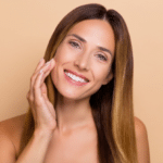 Portrait of attractive cheery long-haired woman touching soft skin