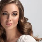 Beauty woman in a white shirt with long and shiny wavy hair