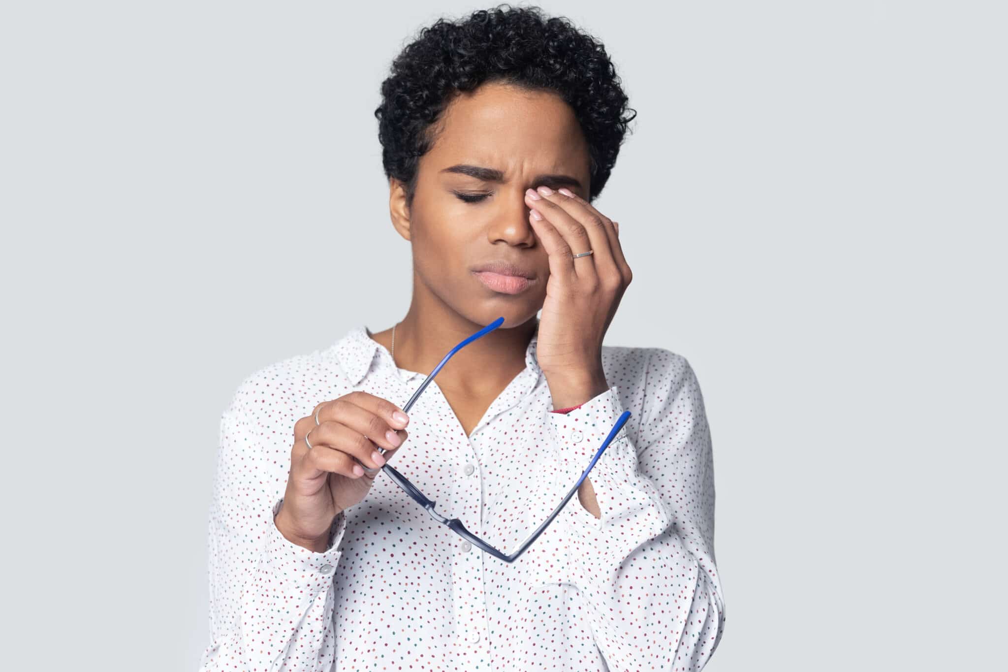 A person with lacrimal disease rubbing their eyes