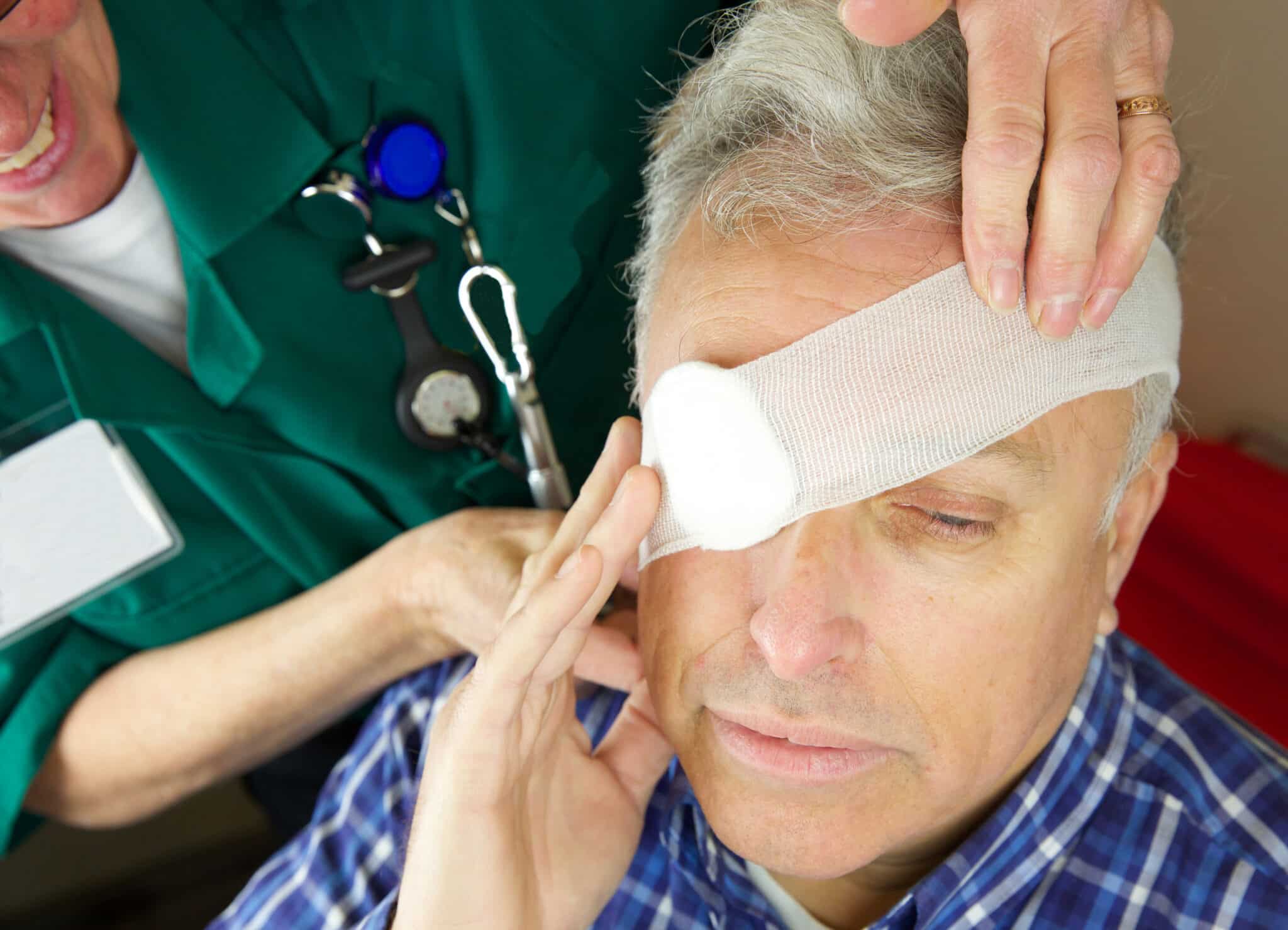 A doctor applying a bandage to a man's eye after orbital trauma